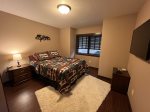 Main level bedroom 1 with queen bed and TV